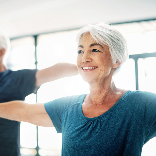 Persona mayor  con audífonos haciendo ejercicio